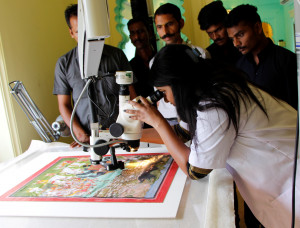 Looking at the artwork closely under the microscope with the conservator 